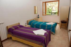 a room with two beds and a window at Elena Residence in Torchiara