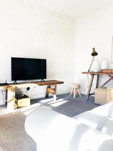 sala de estar con TV de pantalla plana en la pared en Charming Design House in Montijo, Casa 41 en Montijo