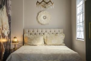 a bedroom with a white bed with a chandelier above it at Boutique City Villa in Old Town in Plovdiv