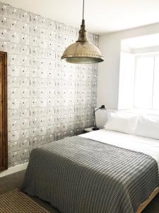 1 dormitorio con 1 cama grande y luz colgante en Charming Design House in Montijo, Casa 41 en Montijo