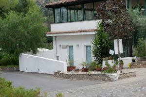 a white house with a fence in front of it at Elena Residence in Torchiara