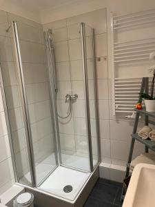 a shower with a glass door in a bathroom at Ostseestrand-Apartments in Nienhagen
