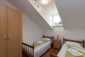 a bedroom with two beds and a window at Apartment Zora in Čilipi