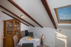 a dining room with a table and a window at Apartment Zora in Čilipi