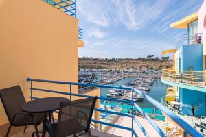 een balkon met een tafel en stoelen en een jachthaven bij Admirable 1 bedroom Marina view apt. Albufeira in Albufeira