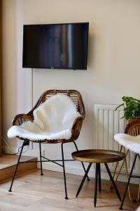 a wicker chair in a living room with a tv at Hofje van Maas in Zandvoort