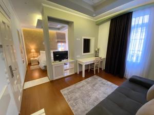 a room with a bed and a television and a couch at HOTEL TSARSI in Kastoria