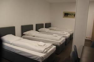 four mattresses lined up in a row in a room at David's Hostel in Geesthacht