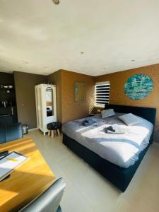 ein Schlafzimmer mit einem großen Bett und einem Tisch in der Unterkunft Dishoek in Dishoek