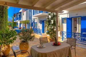 a patio with a table and chairs and buildings at Cretan Dawn Apart, Value Option in Ammoudara in Ayía Marína