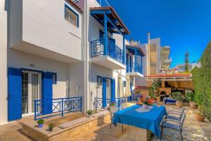 a villa with a blue table and chairs on a patio at apartment in Amoudara of Heraklion-4 in Ayía Marína