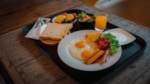 a tray of breakfast food with eggs and toast at Phapok Eco Resort in Ratchaburi