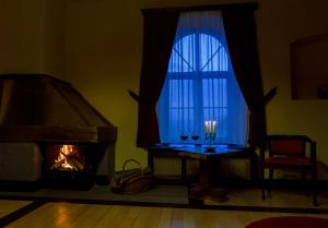 a living room with a fireplace and a table with wine glasses at Castle Hotel Daniel in Baraolt