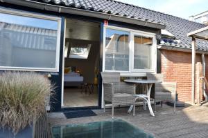 a house with a patio with a table and chairs at Hofje van Maas in Zandvoort