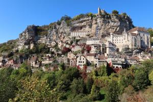 una città su una collina con un castello in cima di l'Ancienne Ecole de Rocamadour dans le Lot a Rocamadour