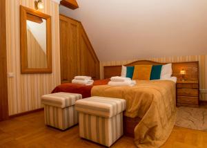 a bedroom with a bed with two ottomans at Vienaragio apartamentai in Palanga