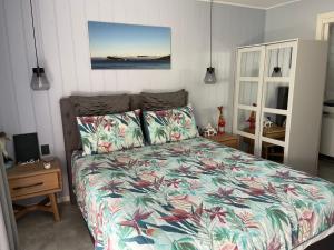 um quarto com uma cama com uma colcha floral em Agapi on Cambridge em Umina