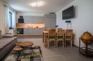 a living room with a table and a kitchen at Astra Lipno in Frymburk