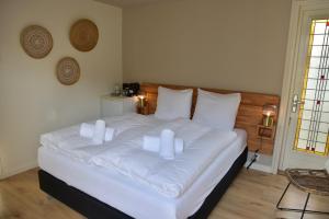 ein Schlafzimmer mit einem weißen Bett mit weißen Kissen in der Unterkunft Hofje van Maas in Zandvoort