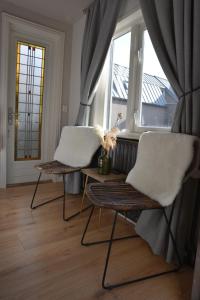 2 stoelen en een tafel in een kamer met een raam bij Hofje van Maas in Zandvoort