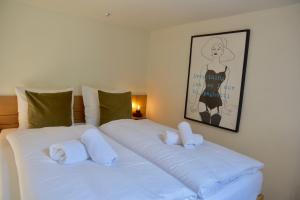 1 Schlafzimmer mit 2 Betten und weißen Kissen in der Unterkunft Hofje van Maas in Zandvoort