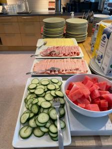 een buffet met komkommers komkommers en een kom watermeloen en een bord bij HOTEL N Hostel Malmö City in Malmö