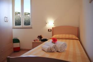 a bedroom with a bed with towels on it at Hotel L'Ancora in Capo Vaticano