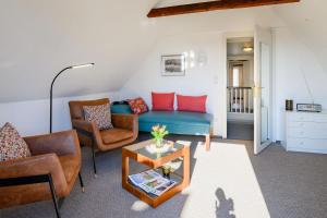 a living room with a blue couch and two chairs at stadthaus husum in Husum