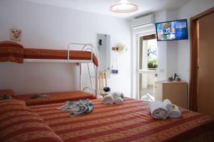 una camera con 2 letti a castello e asciugamani su un letto di Hotel L'Ancora a Capo Vaticano