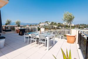 eine Terrasse mit einem Tisch und Stühlen auf dem Balkon in der Unterkunft Happyfew Le Lucia in Nizza