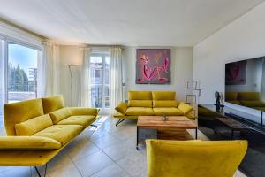 un soggiorno con divani gialli e tavolo di Happyfew Le Lucia a Nizza