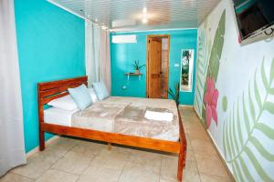 a bedroom with a bed and a blue wall at Hostel Travelers Chitre in Chitré