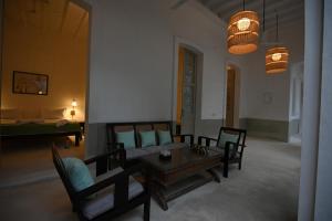 a living room with a couch and a table at La Cedille - French Heritage House in Puducherry