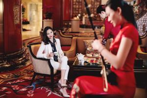 a woman sitting in a chair in a room at China World Hotel, Beijing, A Shangri-La Hotel in Beijing