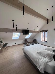 Un dormitorio con una gran cama blanca y una mesa en Brasserie du Simonis en Laforêt
