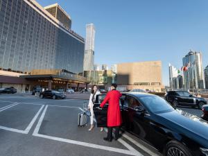 a man and woman getting out of a car at China World Hotel, Beijing, A Shangri-La Hotel in Beijing