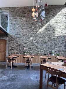 un restaurante con mesas de madera y una pared de ladrillo en Brasserie du Simonis en Laforêt