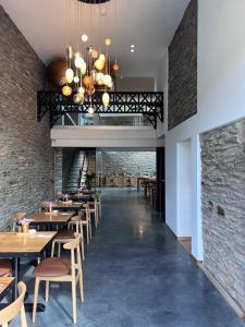 un restaurante con mesas y sillas y una pared de ladrillo en Brasserie du Simonis en Laforêt