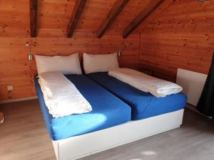 Cama grande en habitación con paredes de madera en Tschuggen 4 en Blatten bei Naters