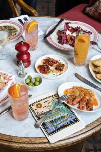 a table with plates of food and drinks on it at The Princess Royal, Nothing Hill in London