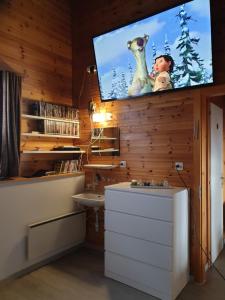 sala de estar con TV en la pared y lavamanos en Tschuggen 4 en Blatten bei Naters