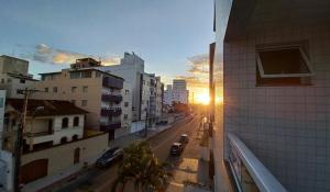 Lindo apartamento com Wi-Fi a 370m da Praia do Morro, próximo ao Marlim Azul e à Av Paris في غواراباري: منظر لشارع المدينة عند غروب الشمس من أحد المباني