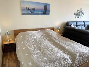 ein Schlafzimmer mit einem Bett und einem Sofa in der Unterkunft Fehmarn Burgtiefe Südstrand Whg SEESTERN in Fehmarn