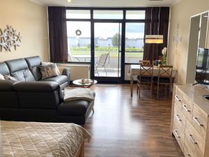 ein Wohnzimmer mit einem Sofa und einem Tisch in der Unterkunft Fehmarn Burgtiefe Südstrand Whg SEESTERN in Fehmarn