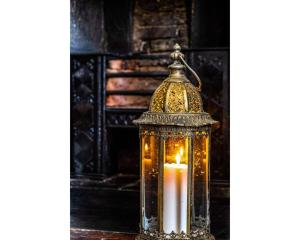 a candle in a glass lantern on a table at Bennett's Lodgings a luxurious 2 bed apartment in Bath
