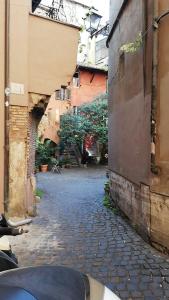 Une allée avec une moto garée à côté d'un bâtiment dans l'établissement Apartments Campo de Fiori, à Rome