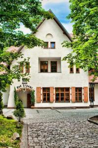 ein großes weißes Haus mit einer Kopfsteinpflasterstraße in der Unterkunft Giszowiec Pokoje gościnne Przyjazna 9 in Kattowitz