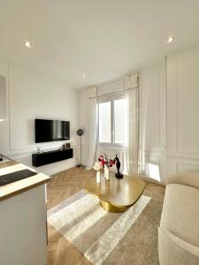 uma sala de estar com uma mesa de centro e uma televisão em L incomparable - International Palace em Vichy