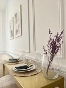 uma mesa com um prato e um vaso com uma planta em L incomparable - International Palace em Vichy