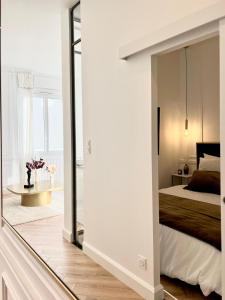 a bedroom with a large mirror next to a bed at L incomparable - International Palace in Vichy
